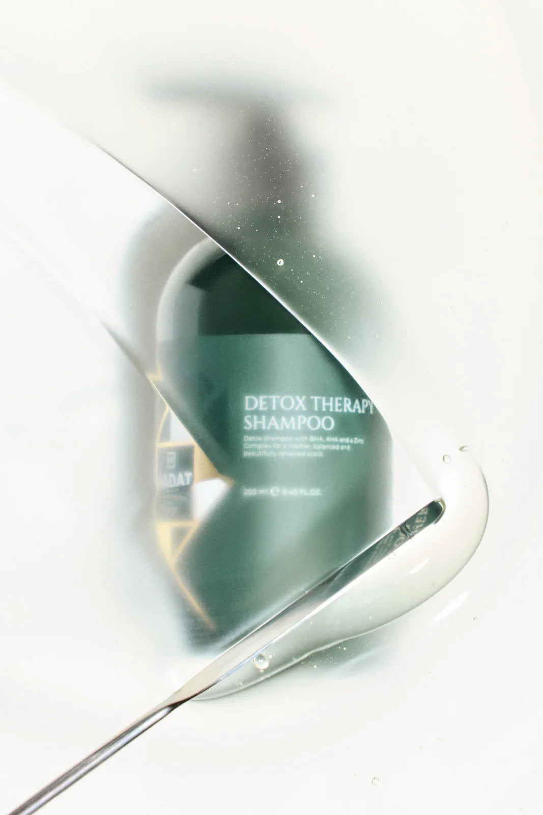 Detox Therapy Shampoo 250 ml behind a translucent water veil