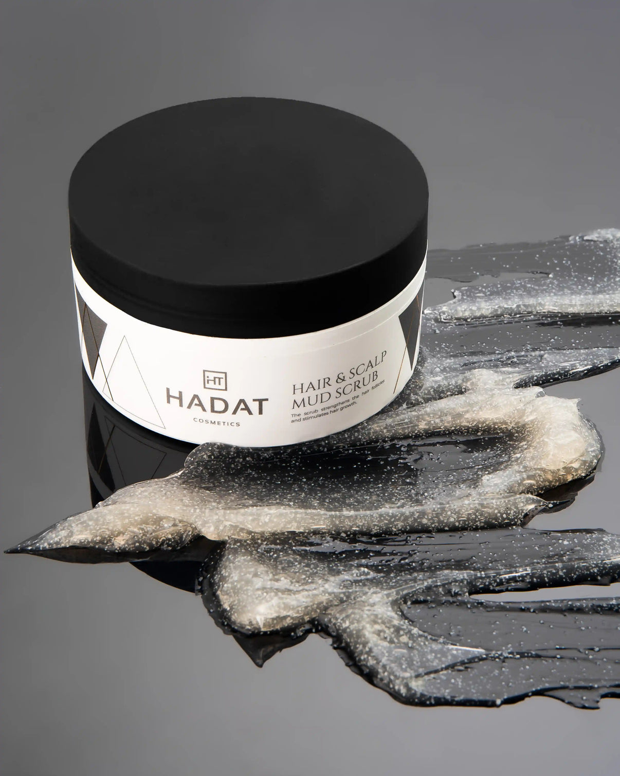 Hair & Scalp Mud Scrub jar with shimmering product swatch
