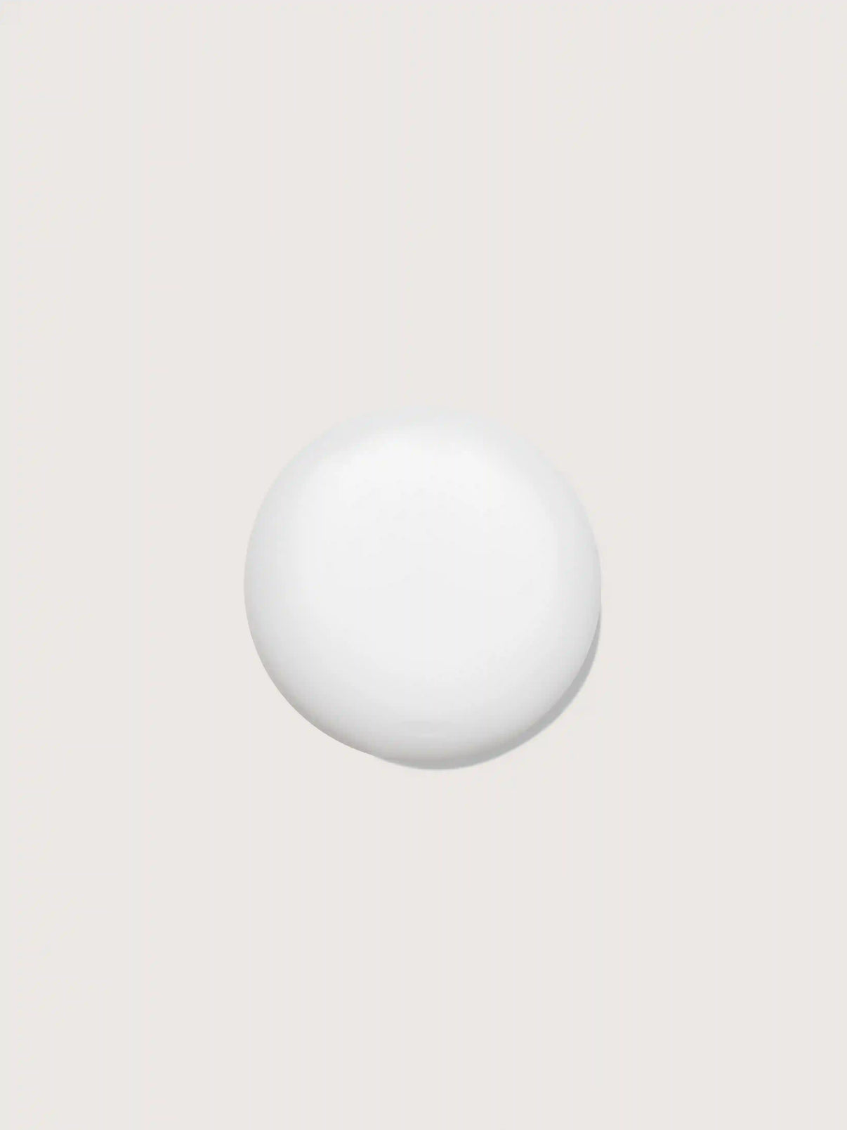 Smooth white cosmetic sphere on neutral background