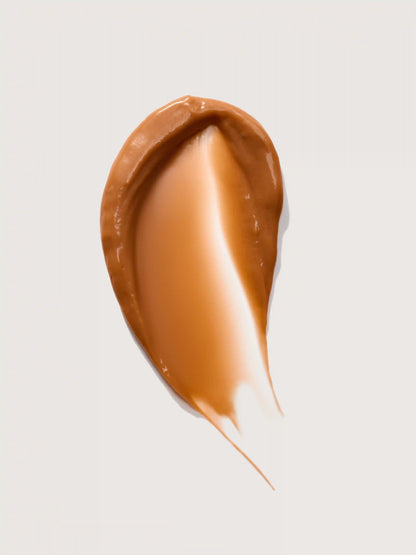 Smooth brown cosmetic cream swatch on white background
