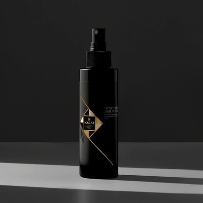 Hadat Hydro Aura Hair Serum bottle with gold accents on dark background