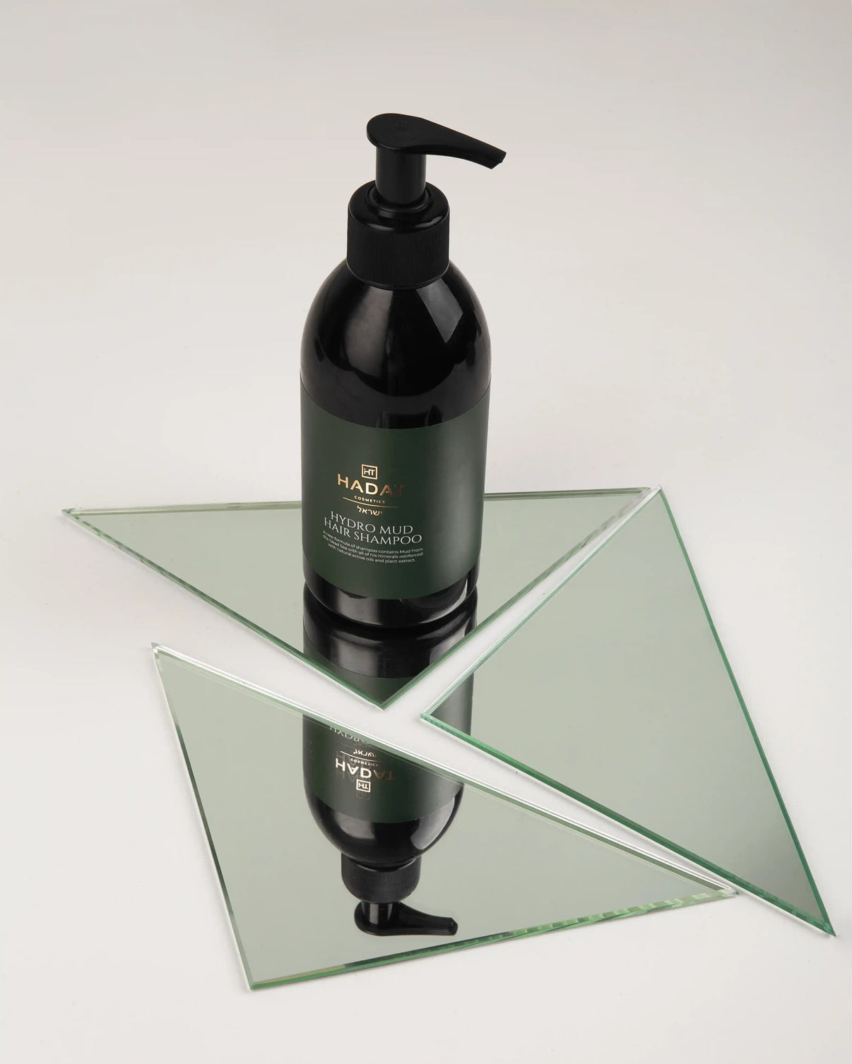 Hadat Hydro Mud Hair Shampoo bottle on glass stand