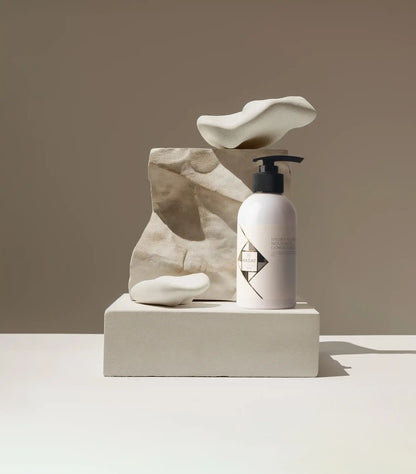 Hadat Hydro Nutrient Nourishing Conditioner bottle with minimalist stone props
