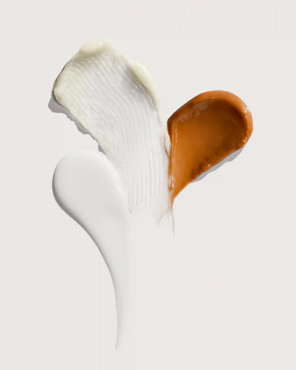 Creamy white and golden brown cosmetic swatches on light background