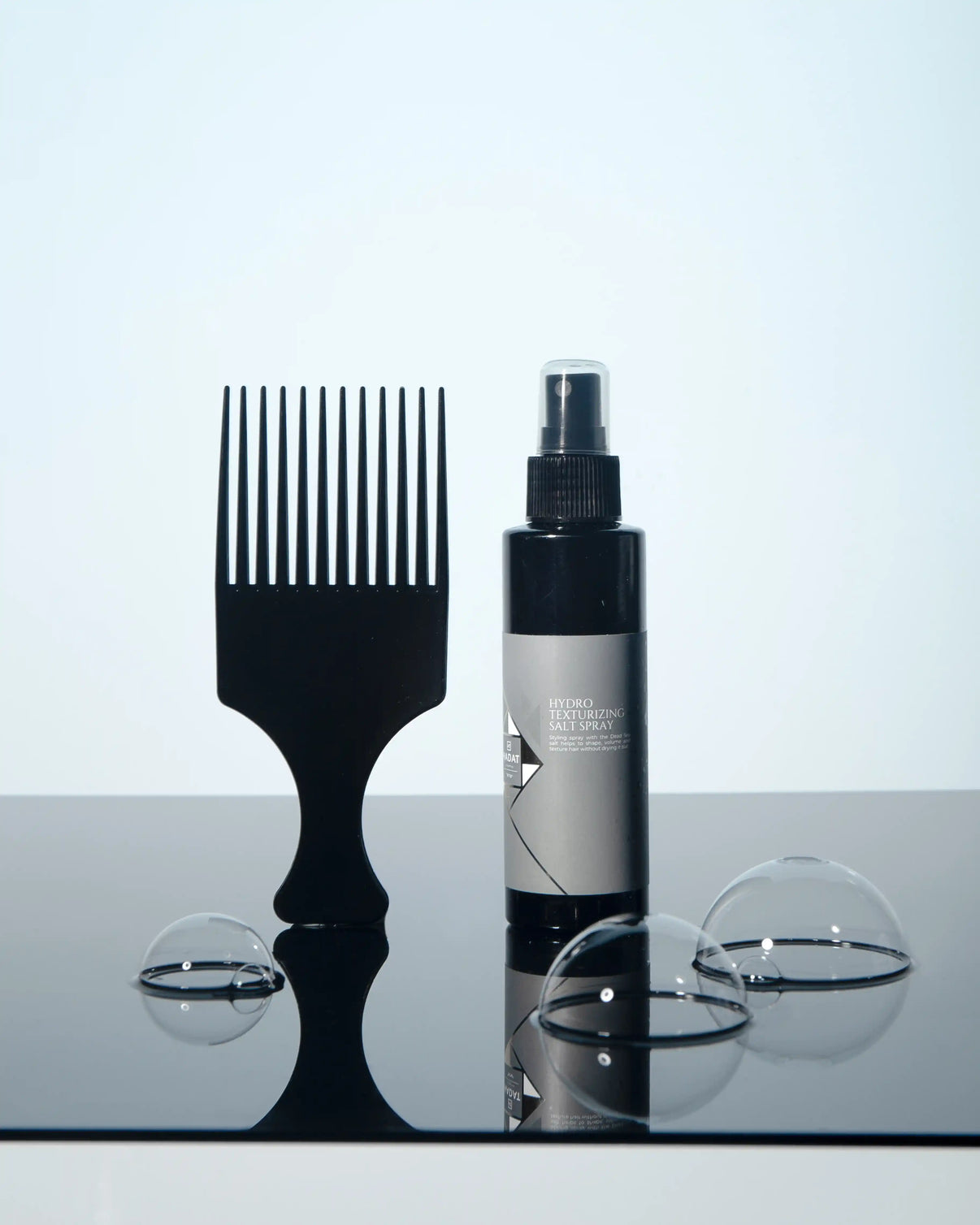 Hydro Texturizing Salt Spray with wide-tooth comb and bubbles on reflective surface